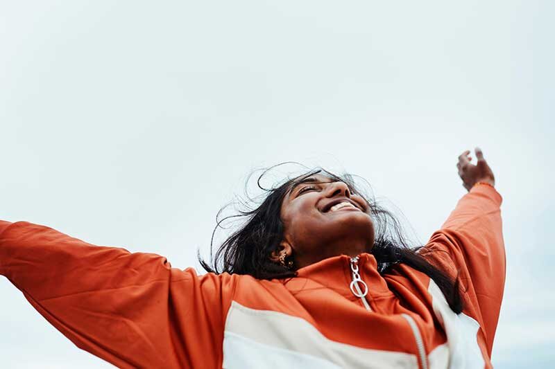 • Spliff Second cannabis industry newton ma - happy woman with arms upraised to the sky